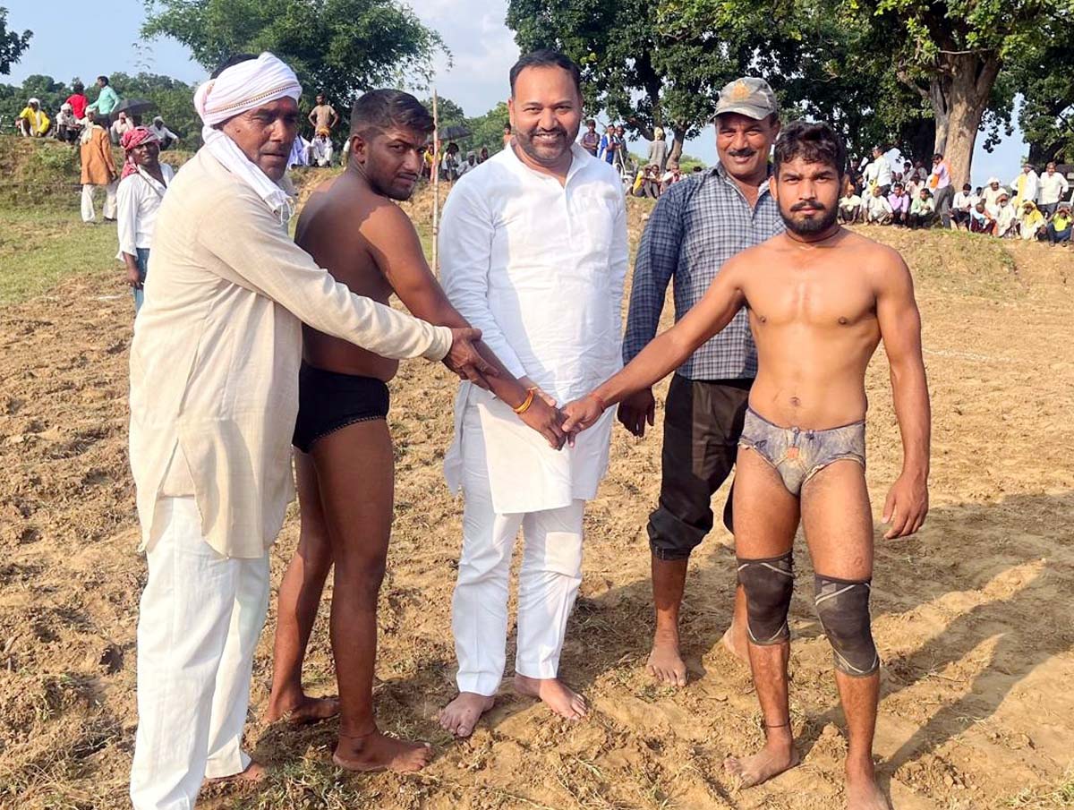 पहलवानों का हाथ मिलवाकर कुश्ती शुरू कराते मुख्य अतिथि